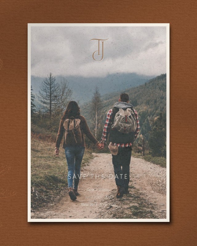 Bliss & Bone photo save the date card featuring a couple walking a mountain trail, warm terracotta tones with monogram detail